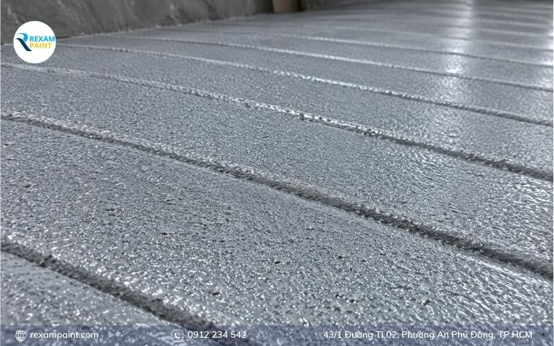 Cận cảnh lớp sơn epoxy pha cát tạo độ nhám trên mặt dốc bê tông