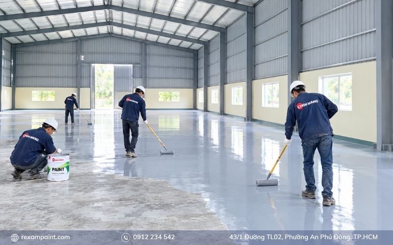 Công nhân đang lăn lớp sơn phủ epoxy Chokwang trên nền nhà xưởng đã xử lý