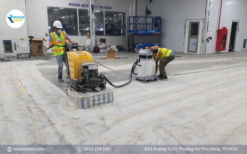 Công nhân mài và làm sạch nền bê tông trước khi sơn epoxy 2K