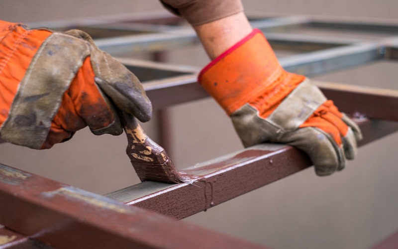 Công nhân thi công lớp sơn lót epoxy lên bề mặt thép đã làm sạch