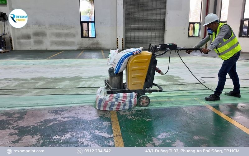 Máy mài sàn bê tông công nghiệp đang tạo nhám bề mặt trước khi thi công epoxy