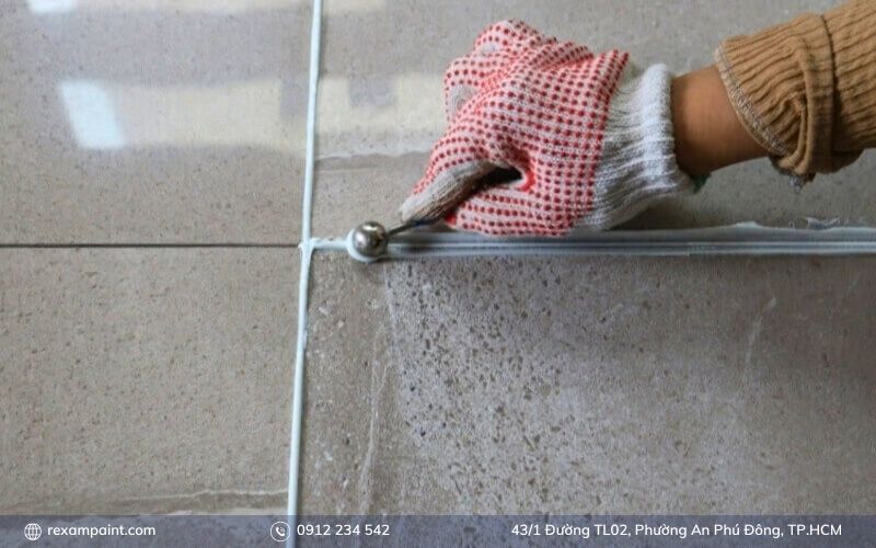 Người thợ đang trét keo dán gạch epoxy lên nền để ốp gạch khu vực ẩm ướt