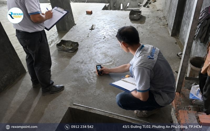 Nhân viên kỹ thuật khảo sát và đo độ ẩm sàn tầng hầm để lập báo giá
