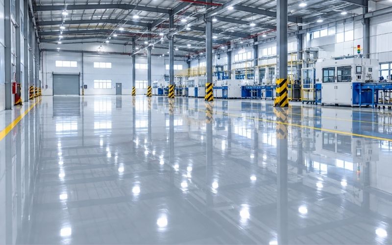Sàn nhà xưởng phủ sơn bóng epoxy phản chiếu ánh đèn như mặt gương
