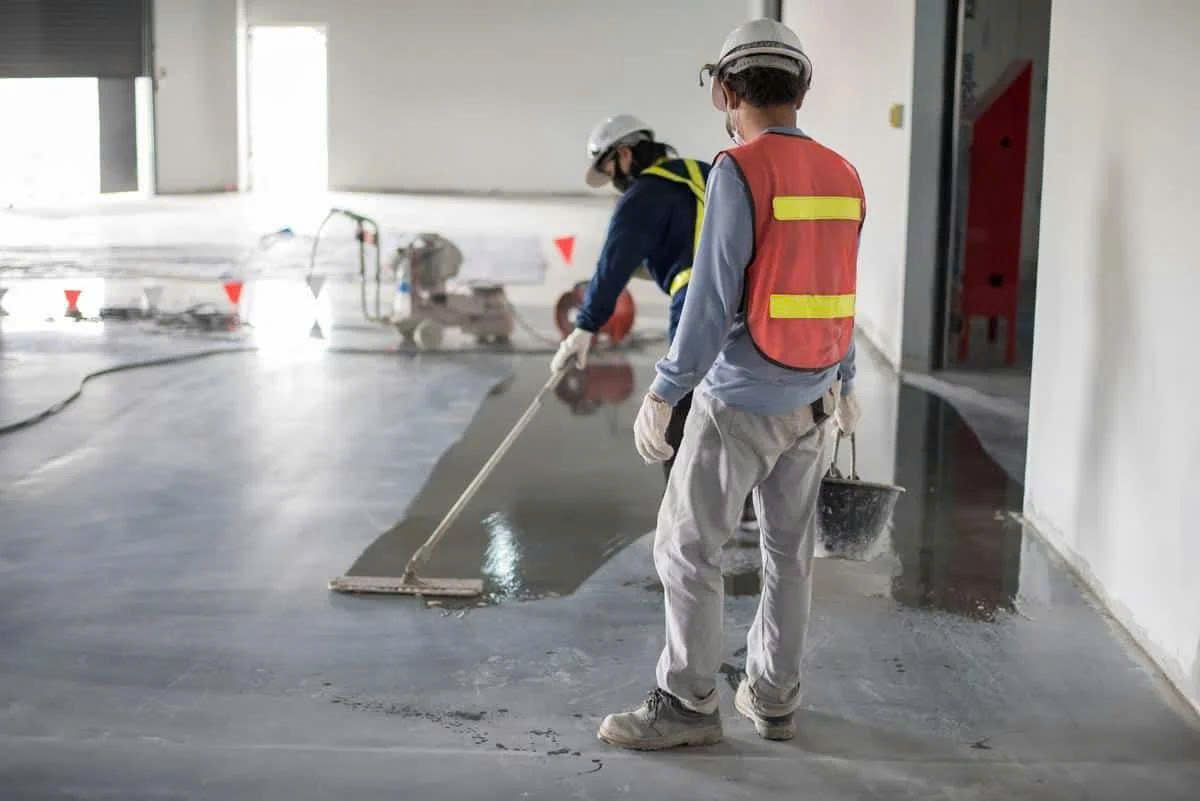 Thợ đang lăn lớp phủ epoxy tự san phẳng lên nền tạo vân giả bê tông