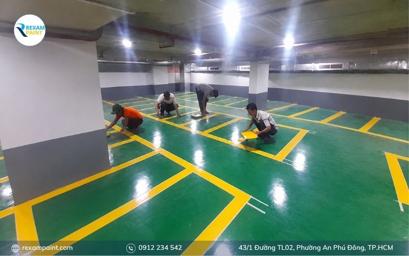 Thợ thi công đang lăn lớp sơn epoxy lót cho sàn tầng hầm